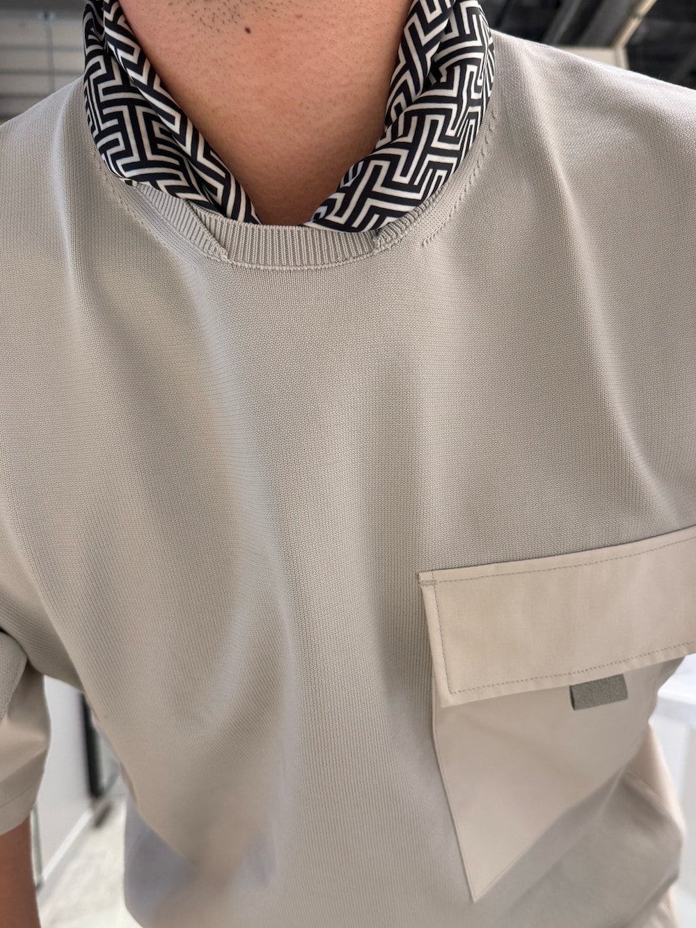 グレー系のニット/セーター、グレー系のスラックス、ブラック系のストール/ショールを着用したメンズの夏コーディネートの4枚目の写真