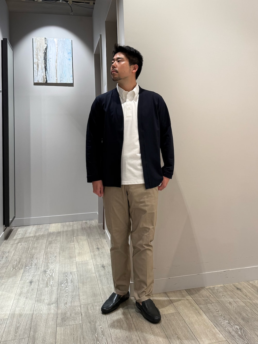 ブルー系のカーディガン/ボレロ、ホワイト系のポロシャツ、ベージュ系のスラックスを着用したメンズの夏コーディネートの4枚目の写真