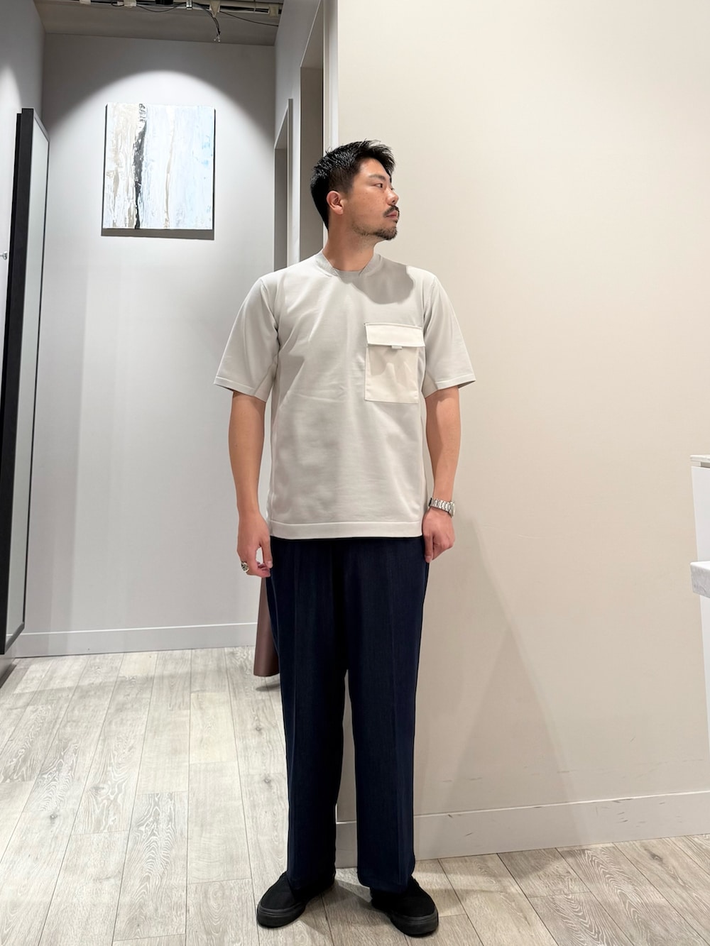グレー系のニット/セーター、ブルー系のスラックスを着用したメンズの春コーディネートの2枚目の写真