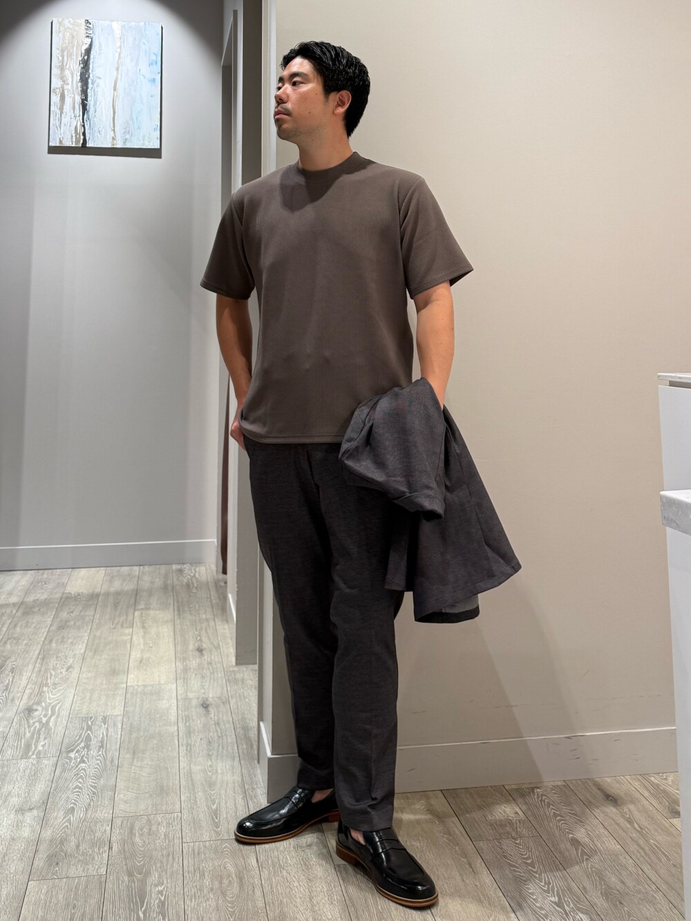 ブラウン系のTシャツ/カットソー、グレー系のスラックス、グレー系のセットアップを着用したメンズの秋コーディネートの4枚目の写真