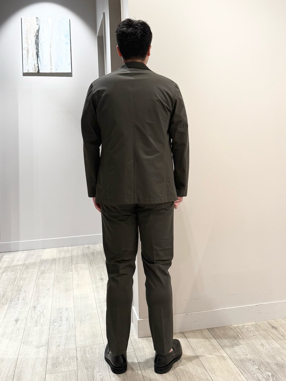 ブラウン系のテーラードジャケット、ブルー系のTシャツ/カットソー、ブラウン系のスラックスを着用したメンズの夏コーディネートの3枚目の写真