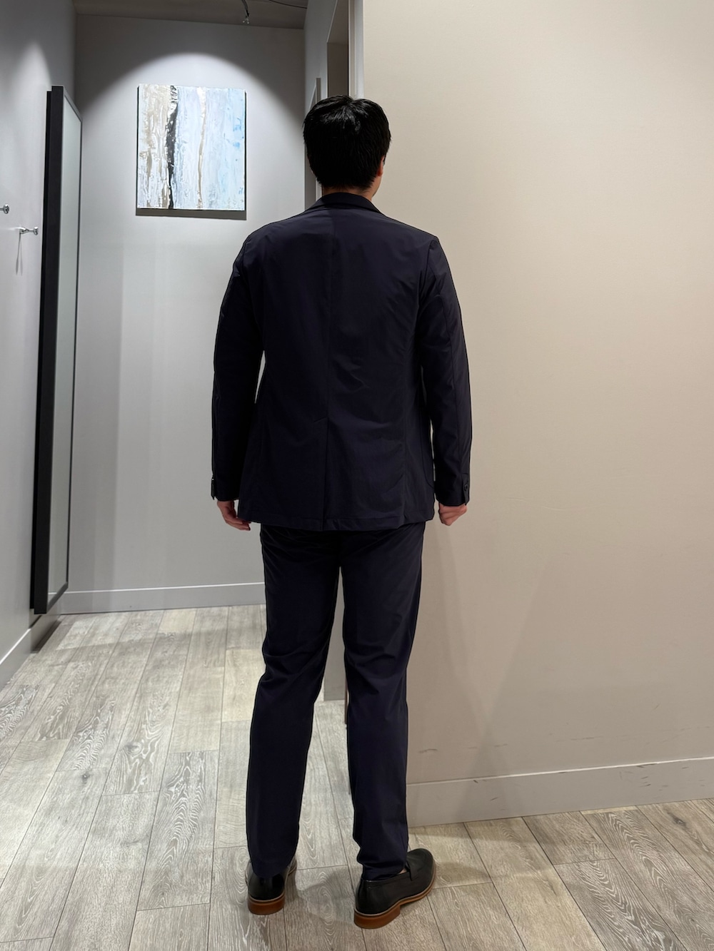 ブルー系のテーラードジャケット、ブルー系のスラックス、ベージュ系のTシャツ/カットソーを着用したメンズの秋コーディネートの3枚目の写真