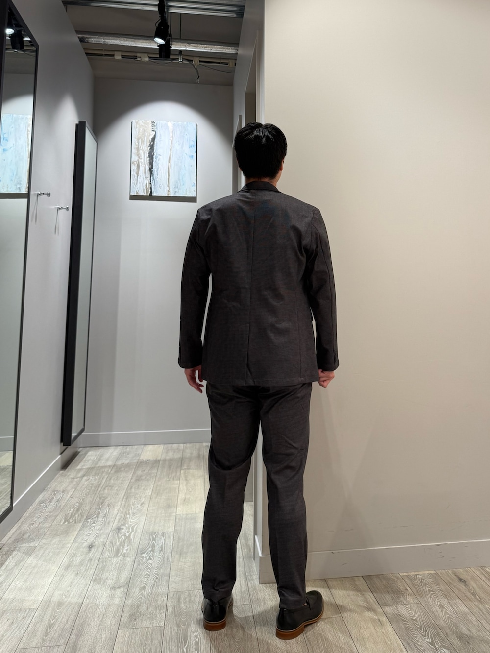 ブラウン系のTシャツ/カットソー、グレー系のスラックス、グレー系のセットアップを着用したメンズの秋コーディネートの3枚目の写真
