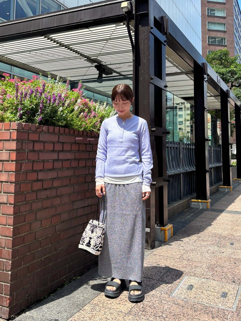 パープル系のニット/セーター、ホワイト系のTシャツ/カットソー、グレー系のスカートを着用したレディースの夏コーディネートの4枚目の写真