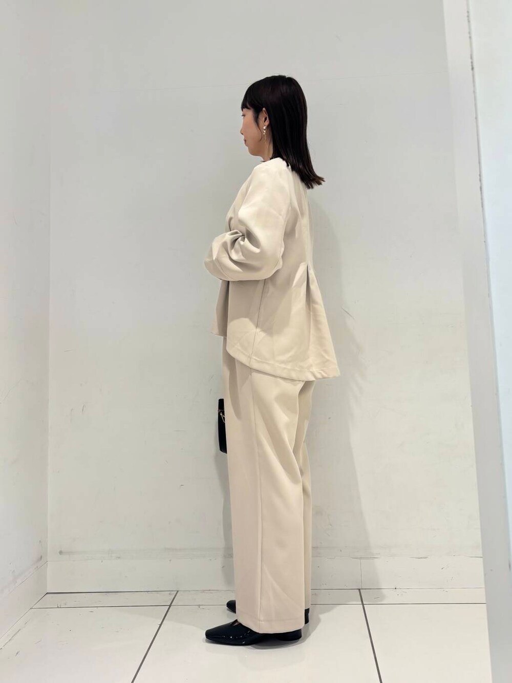 ブラック系のハンドバッグ、ブラック系のTシャツ/カットソー、ブラック系のパンプスを着用したレディースの冬コーディネートの3枚目の写真