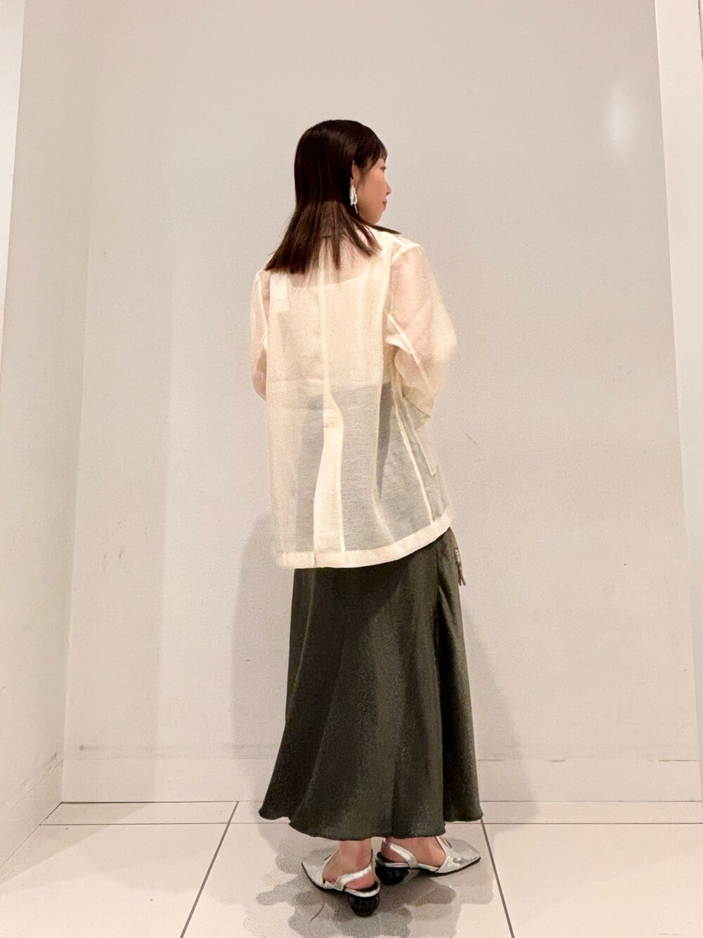 ブラウン系のテーラードジャケット、グリーン系のボストンバッグ、グリーン系のスカートを着用したレディースの秋コーディネートの3枚目の写真