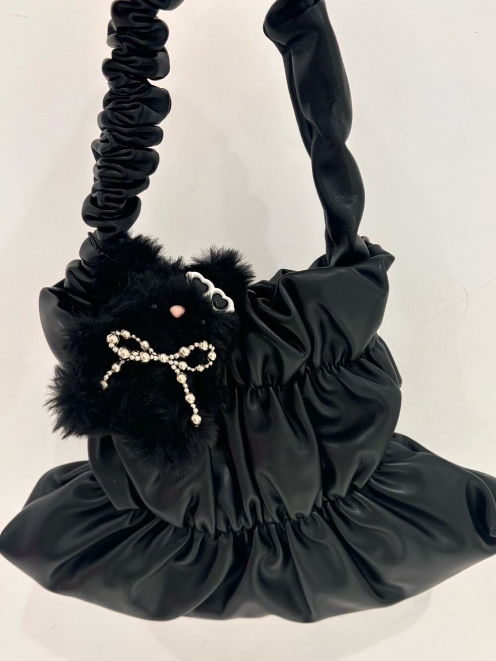 ホワイト系のワンピース、ブラック系のハンドバッグ、ブルー系のデニムパンツを着用したレディースの夏コーディネートの5枚目の写真