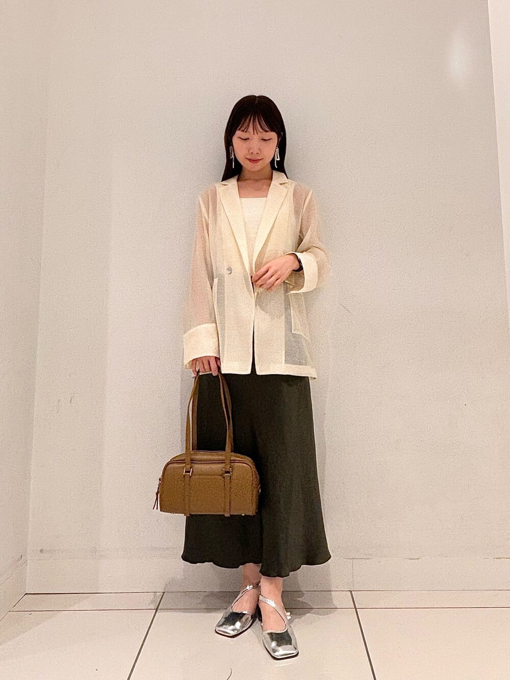 ブラウン系のテーラードジャケット、グリーン系のボストンバッグ、グリーン系のスカートを着用したレディースの秋コーディネートの4枚目の写真