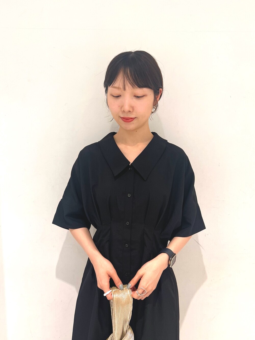 ブラック系のワンピース、ゴールド系のハンドバッグ、グレー系のサンダルを着用したレディースの夏コーディネートの3枚目の写真