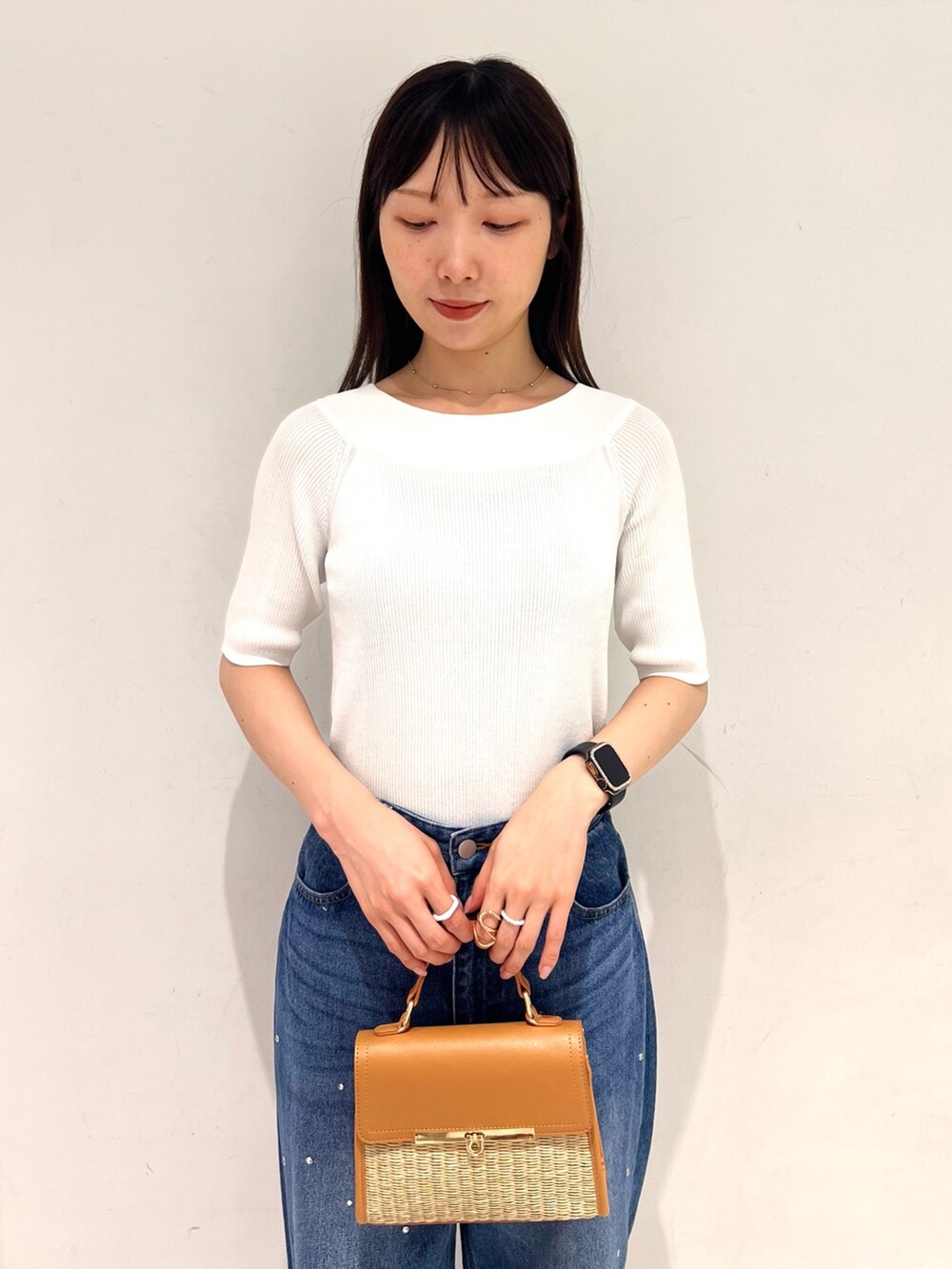 ホワイト系のニット/セーター、ブルー系のデニムパンツ、ブラック系のサンダルを着用したレディースの夏コーディネートの4枚目の写真