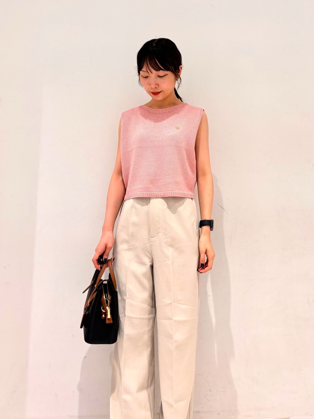 ピンク系のニット/セーター、ベージュ系のその他パンツ、グレー系のサンダルを着用したレディースの夏コーディネートの3枚目の写真