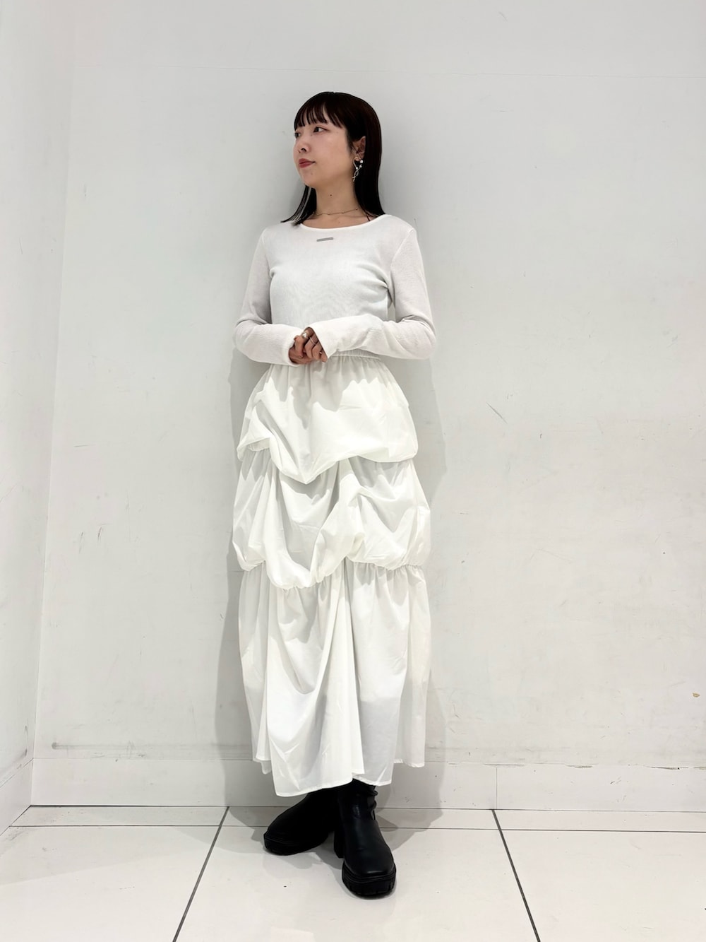 ベージュ系のテーラードジャケット、ホワイト系のTシャツ/カットソー、グリーン系のスカートを着用したレディースの冬コーディネートの2枚目の写真