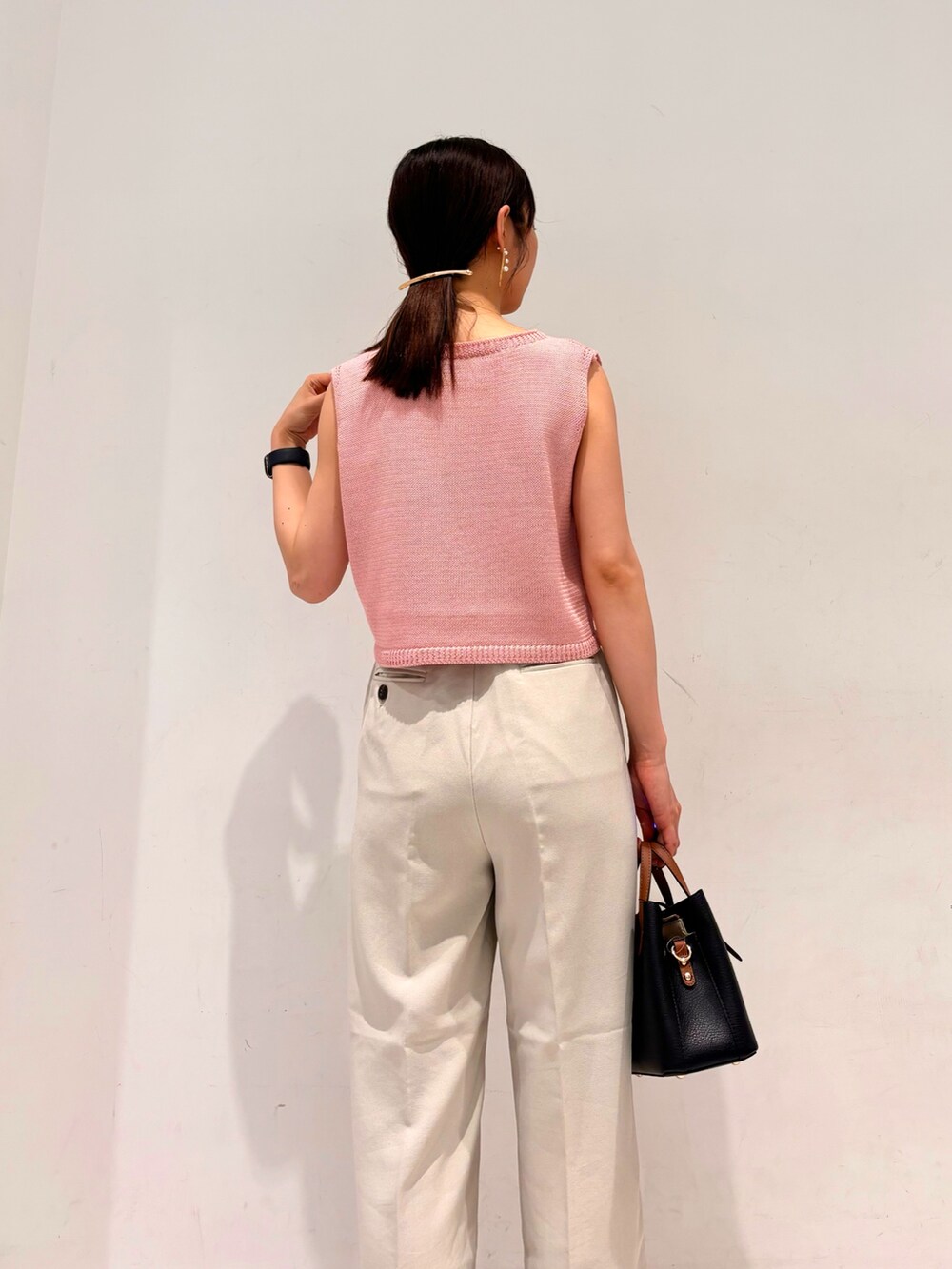 ピンク系のニット/セーター、ベージュ系のその他パンツ、グレー系のサンダルを着用したレディースの夏コーディネートの2枚目の写真