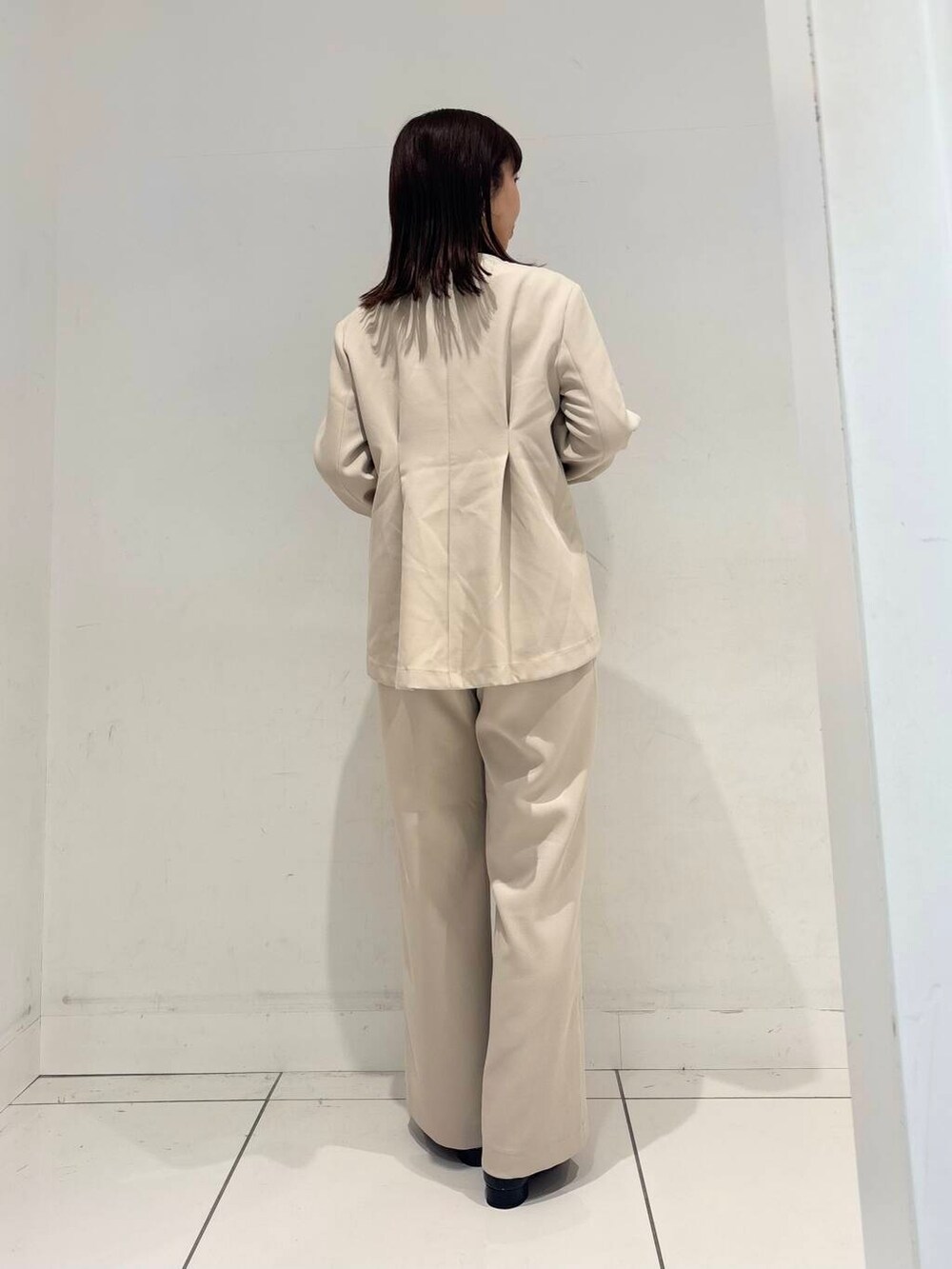 ブラック系のハンドバッグ、ブラック系のTシャツ/カットソー、ブラック系のパンプスを着用したレディースの冬コーディネートの4枚目の写真