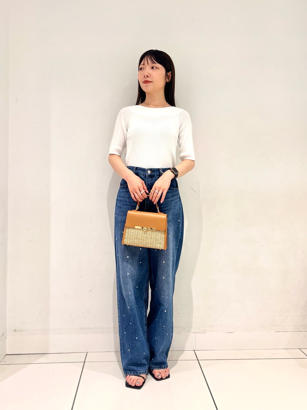 ホワイト系のニット/セーター、ブルー系のデニムパンツ、ブラック系のサンダルを着用したレディースの夏コーディネートの3枚目の写真