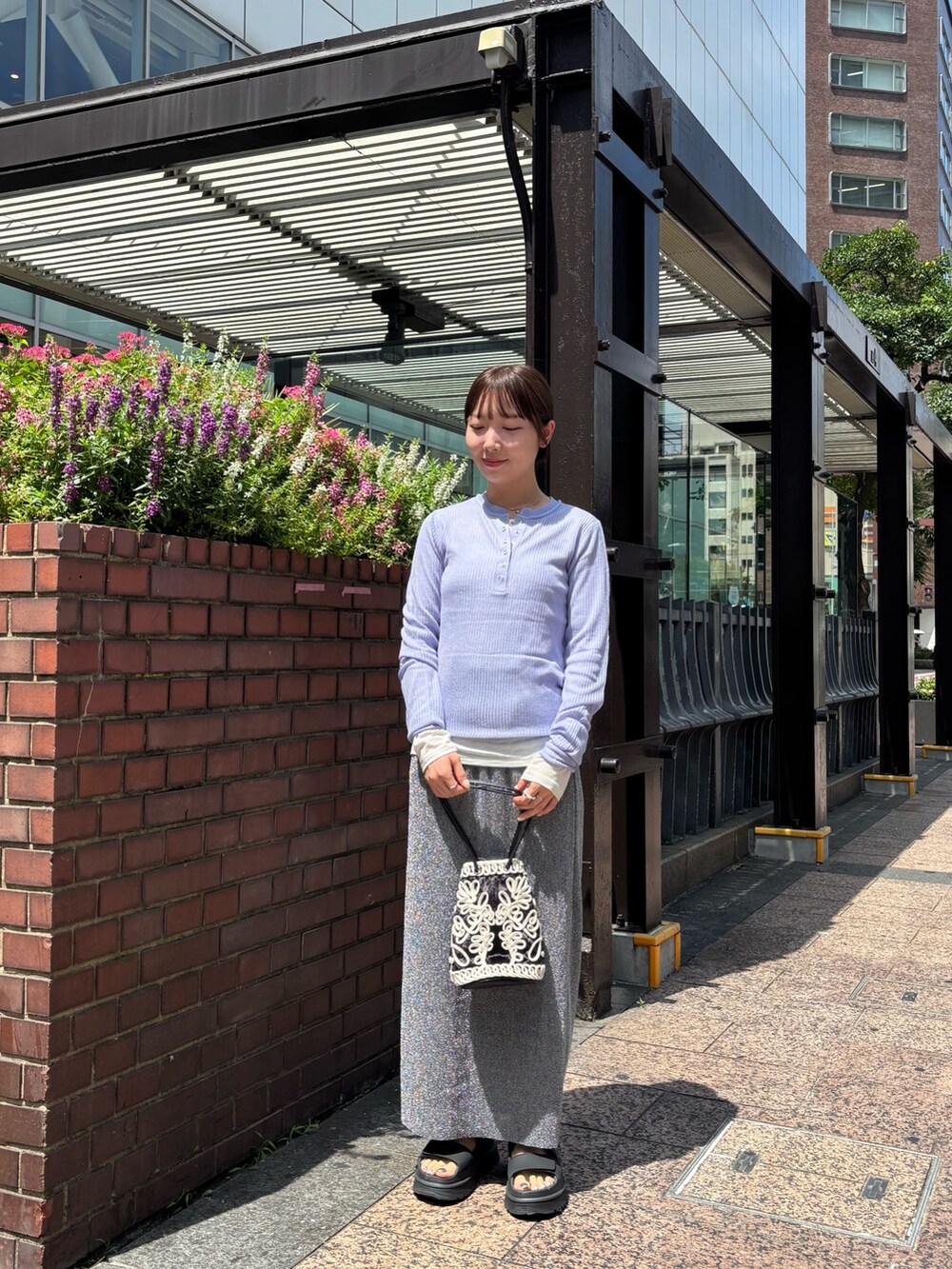 パープル系のニット/セーター、ホワイト系のTシャツ/カットソー、グレー系のスカートを着用したレディースの夏コーディネートの5枚目の写真