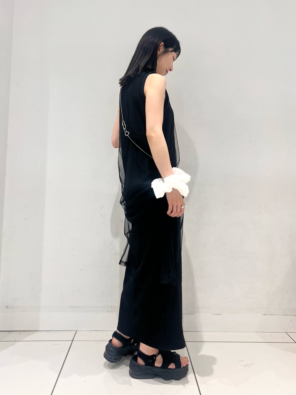 ブラック系のワンピース、シルバー系のサンダル、ホワイト系のヘアゴムを着用したレディースの夏コーディネートの2枚目の写真