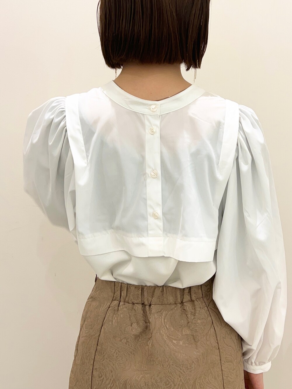 ベージュ系のスカート、ブラウン系のブーツ、ホワイト系のTシャツ/カットソーを着用したレディースの冬コーディネートの3枚目の写真