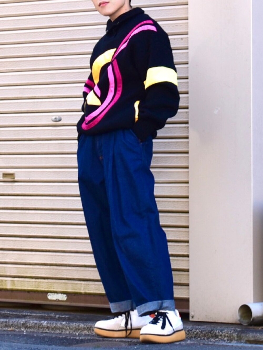 ブラック系のニット/セーター、ブルー系のデニムパンツ、ホワイト系のスニーカーを着用したメンズの冬コーディネートの3枚目の写真