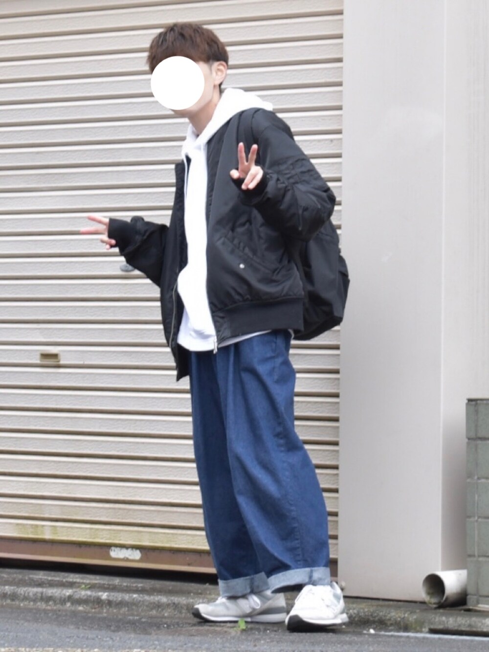 ブラック系のMA-1、ホワイト系のパーカー、ブルー系のデニムパンツを着用したメンズの秋コーディネートの2枚目の写真