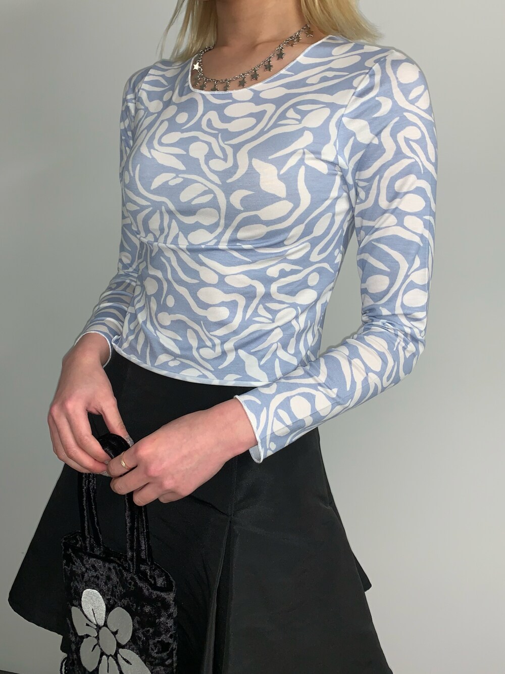 ブルー系のTシャツ/カットソー、ブラック系のハンドバッグ、シルバー系のネックレスを着用したレディースの春コーディネートの3枚目の写真