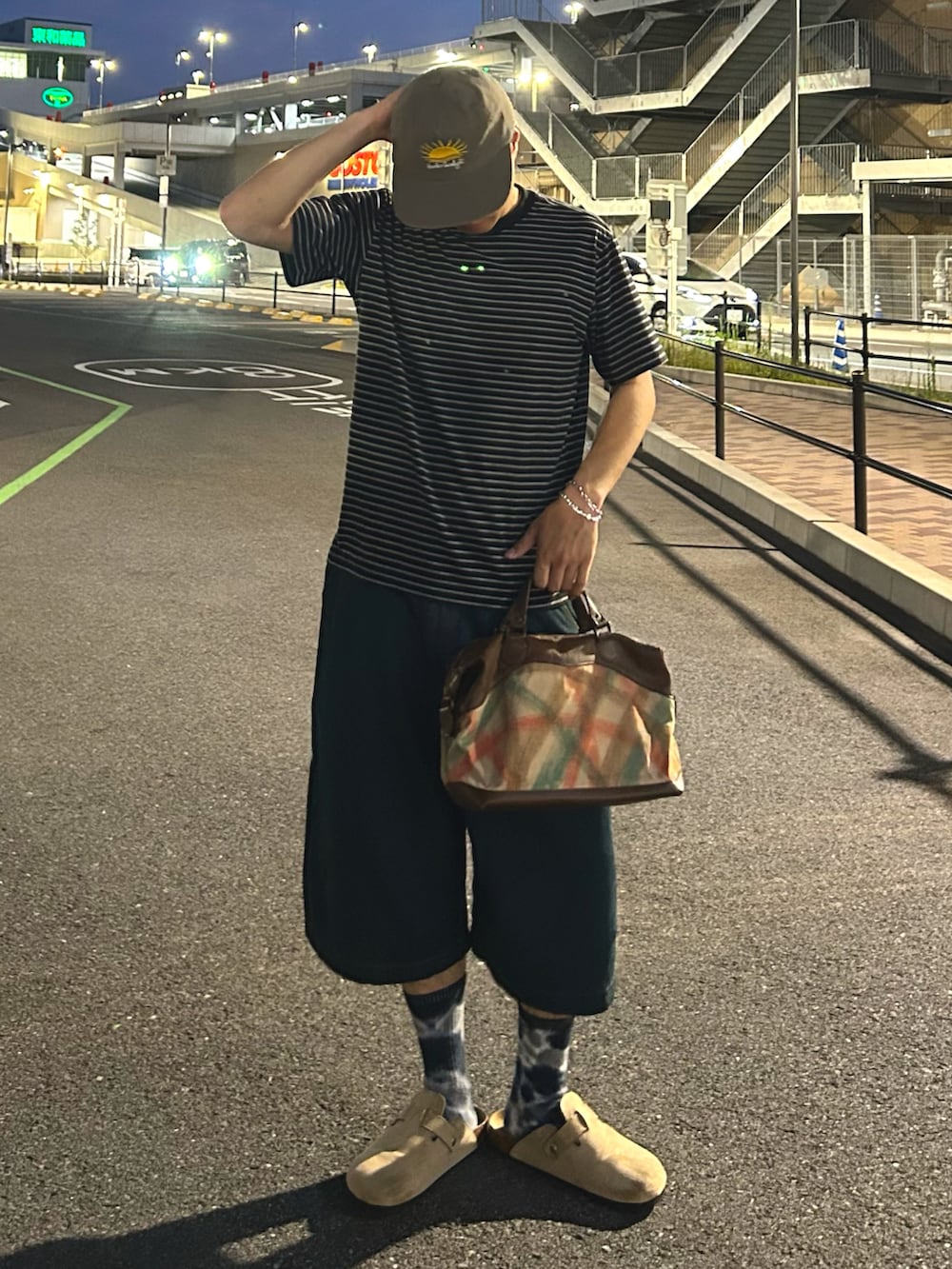 ブルー系のデニムパンツ、ベージュ系のサンダル、ブラック系のTシャツ/カットソーを着用したメンズの夏コーディネートの2枚目の写真