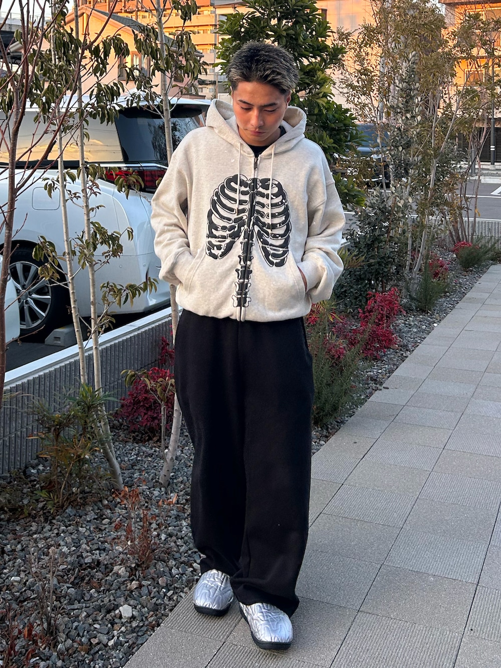 グレー系のパーカー、ブラック系のスウェットパンツ、シルバー系のサンダルを着用したメンズの冬コーディネートの2枚目の写真