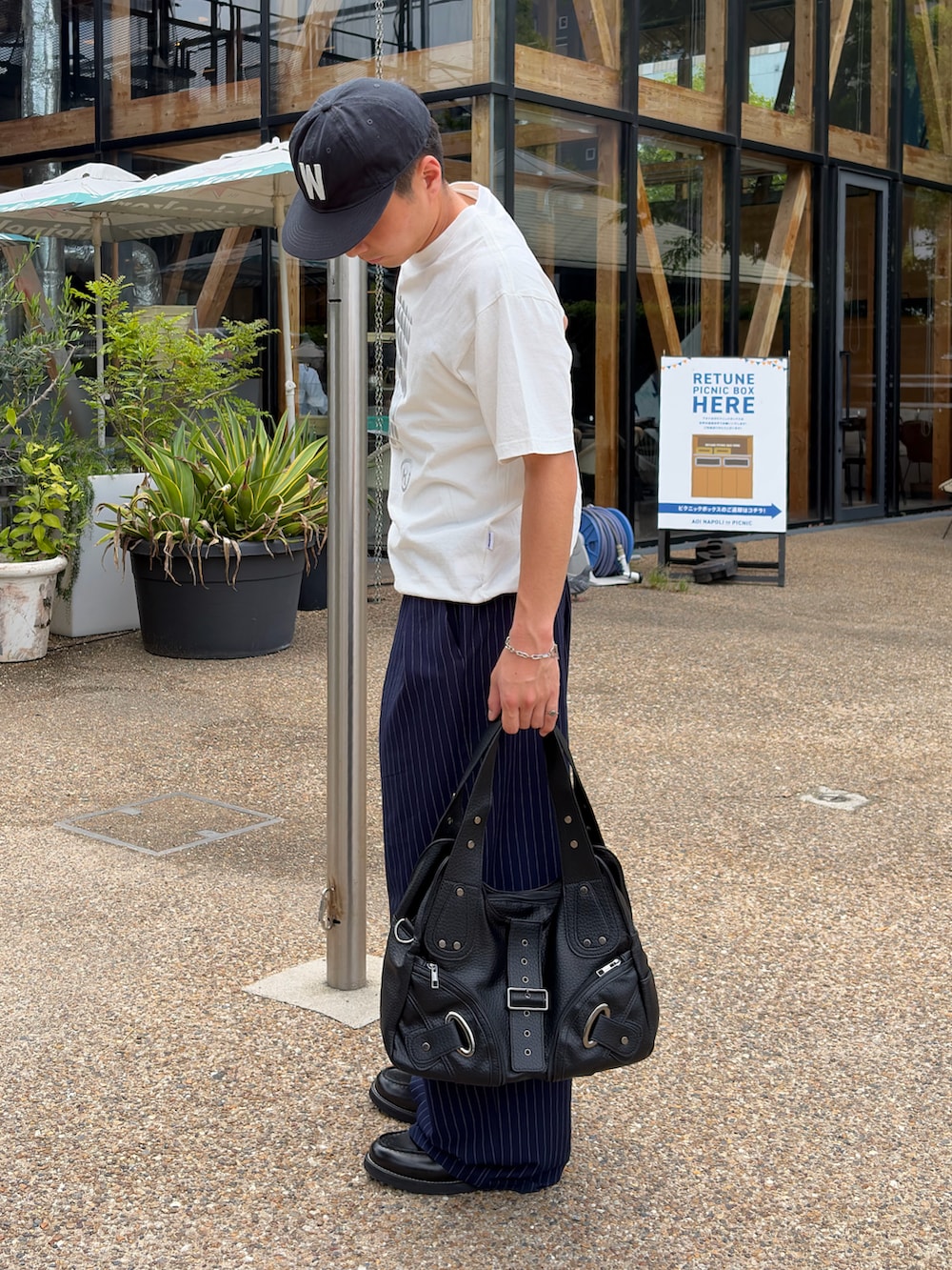 ホワイト系のTシャツ/カットソー、ブルー系のスラックス、ブラック系のショルダーバッグを着用したメンズの夏コーディネートの3枚目の写真