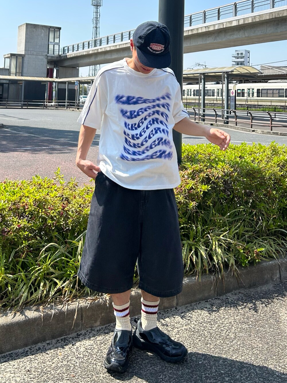 ホワイト系のTシャツ/カットソー、ブラック系のデニムパンツ、ブラック系のスニーカーを着用したメンズの春コーディネートの2枚目の写真