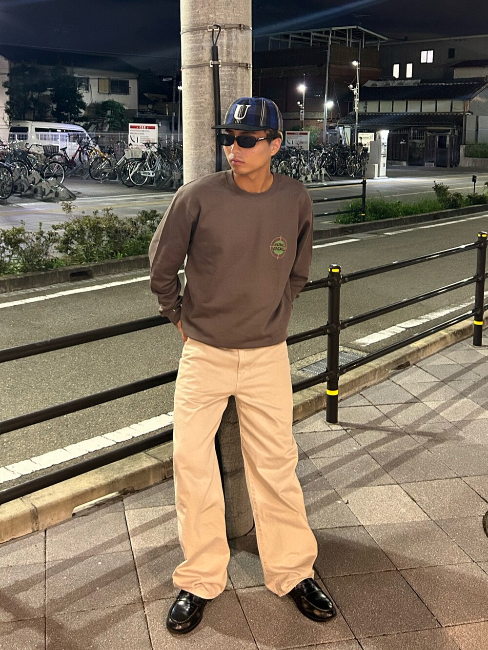 ブラウン系のスウェット、ベージュ系のデニムパンツ、ブラック系のローファーを着用したメンズの秋コーディネートの2枚目の写真