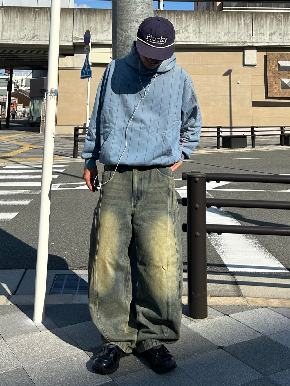 ブルー系のパーカー、ブルー系のデニムパンツ、ブラック系のスニーカーを着用したメンズの秋コーディネートの2枚目の写真