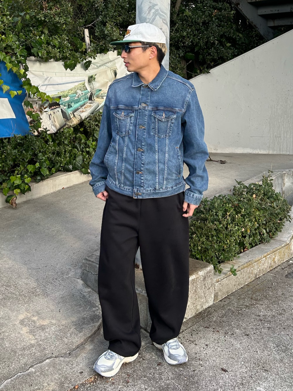 ブルー系のデニムジャケット、ブラック系のスウェットパンツ、シルバー系のスニーカーを着用したメンズの冬コーディネートの2枚目の写真