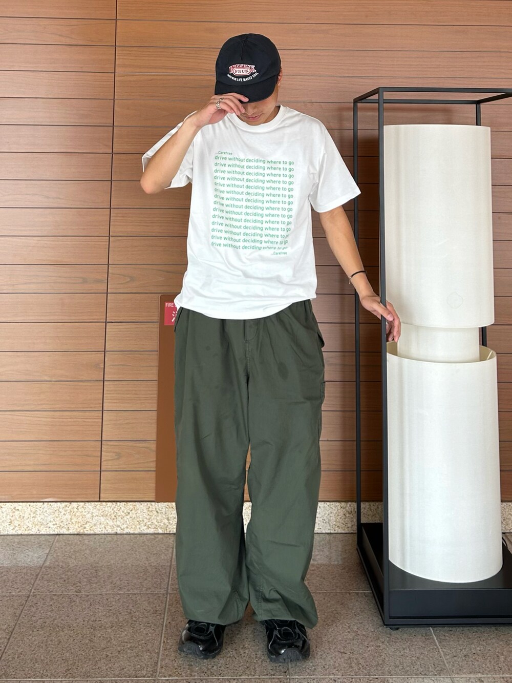 グリーン系のTシャツ/カットソー、グリーン系のカーゴパンツ、ブラック系のスニーカーを着用したメンズの秋コーディネートの2枚目の写真