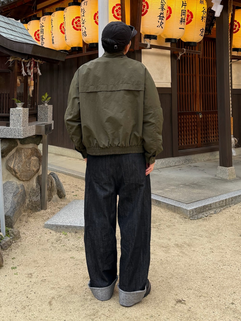 ブラック系のローファー、グリーン系のテーラードジャケット、ブラック系のデニムパンツを着用したメンズの冬コーディネートの2枚目の写真