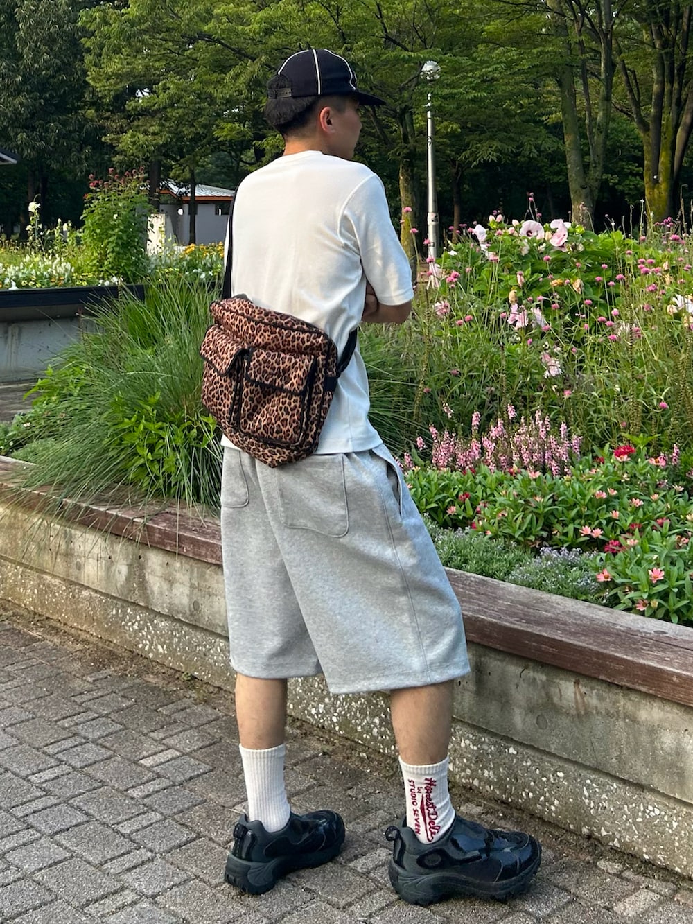 ホワイト系のTシャツ/カットソー、グレー系のスウェットパンツ、その他のショルダーバッグを着用したメンズの夏コーディネートの2枚目の写真