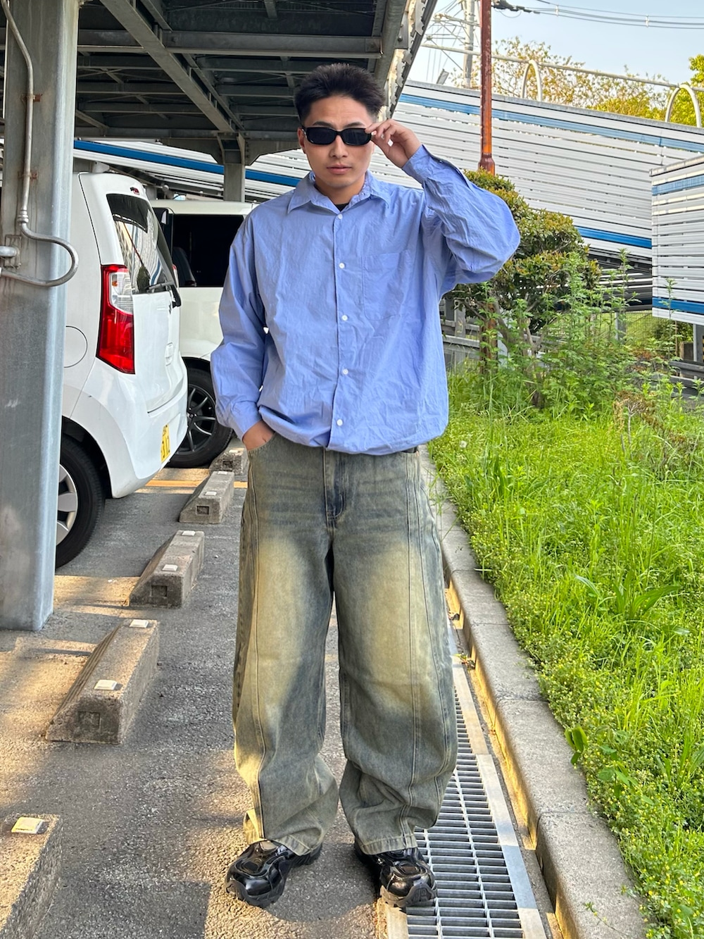 ブルー系のシャツ/ブラウス、ブルー系のデニムパンツ、ブラック系のスニーカーを着用したメンズの春コーディネートの2枚目の写真