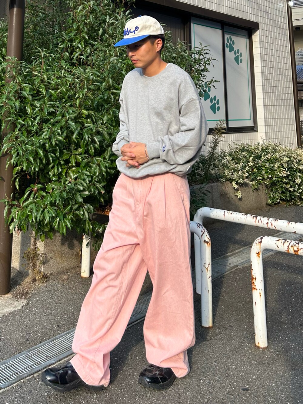 ピンク系のデニムパンツ、グレー系のスウェット、ブラック系のスニーカーを着用したメンズの秋コーディネートの3枚目の写真