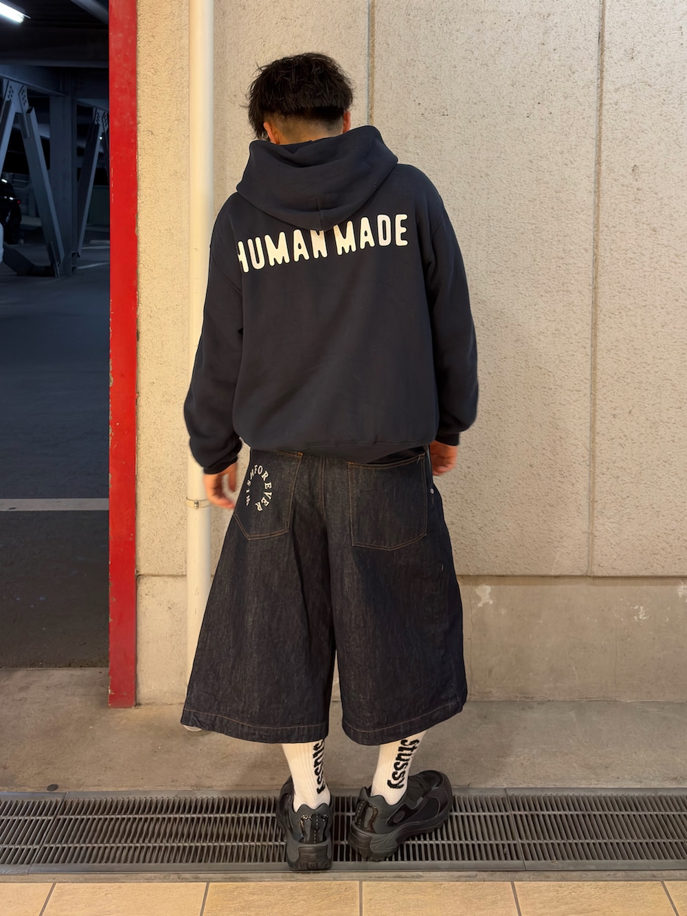 ブルー系のパーカー、ブルー系のデニムパンツ、ブラック系のスニーカーを着用したメンズの春コーディネートの2枚目の写真