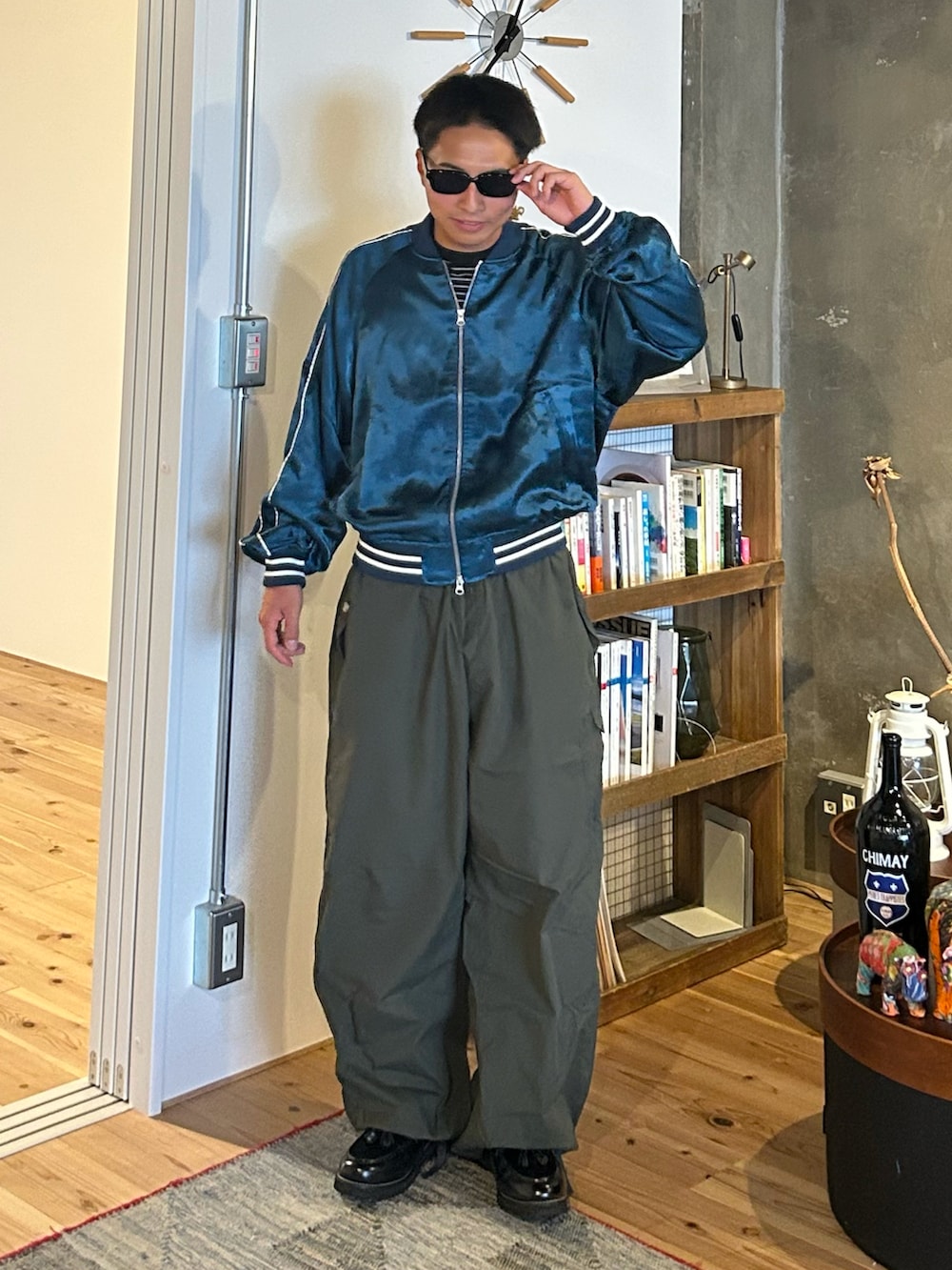 ブルー系のスカジャン、グリーン系のカーゴパンツ、ブラック系のローファーを着用したメンズの秋コーディネートの2枚目の写真