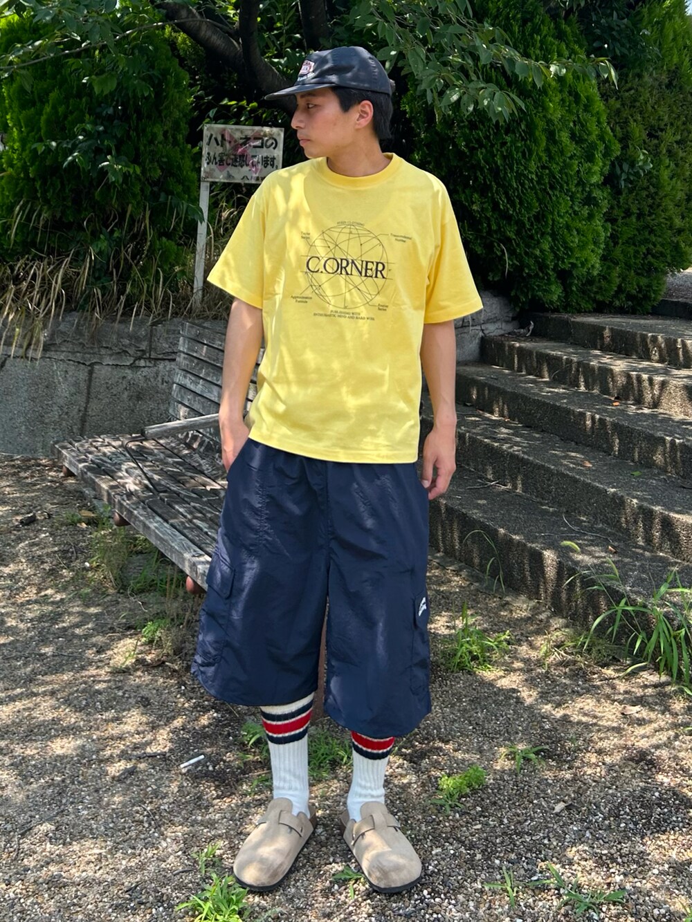 ベージュ系のサンダル、ブルー系のカーゴパンツ、イエロー系のTシャツ/カットソーを着用したメンズの夏コーディネートの2枚目の写真