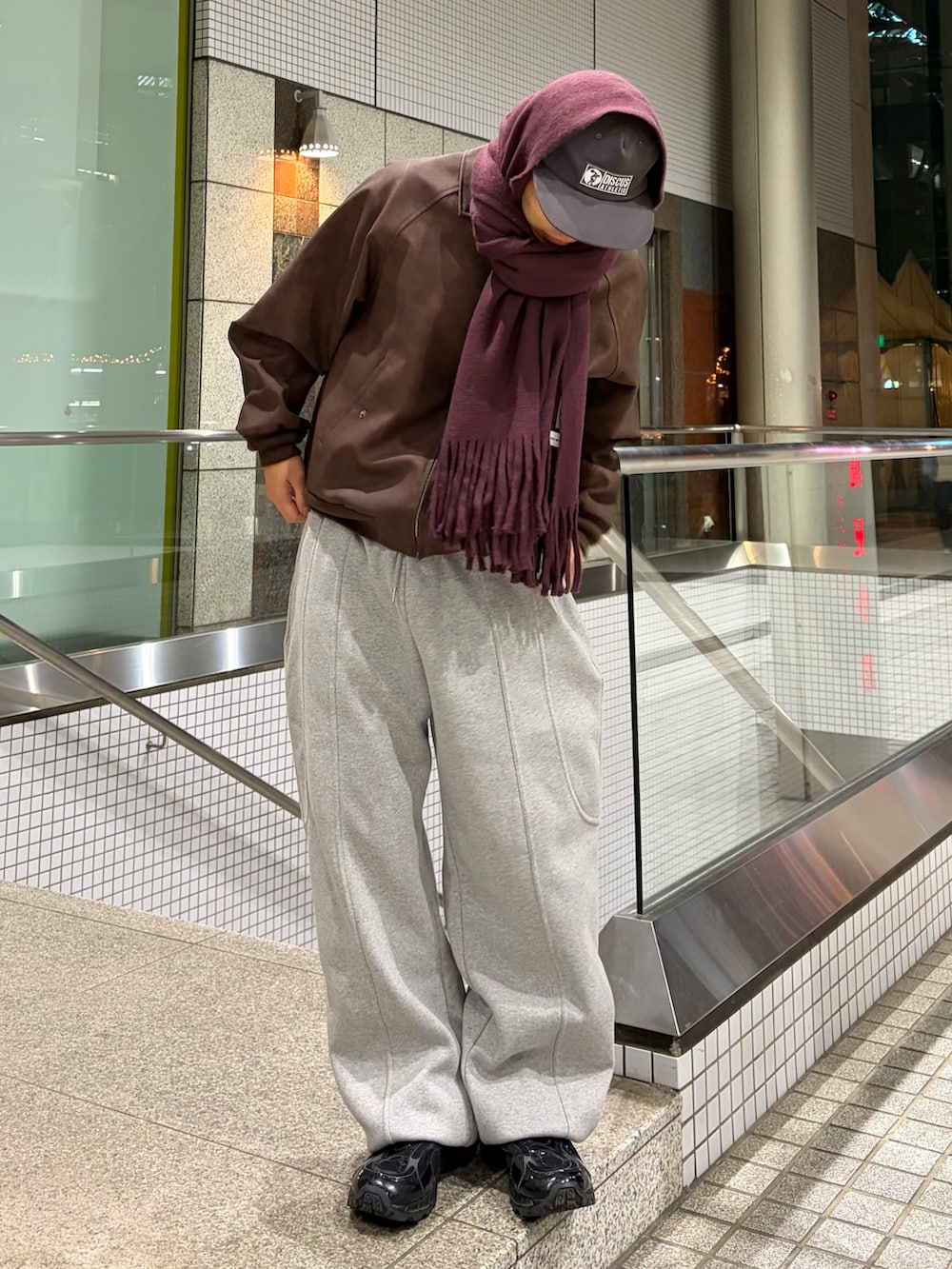 ブラウン系のブルゾン、グレー系のスウェットパンツ、ブラック系のスニーカーを着用したメンズの冬コーディネートの2枚目の写真