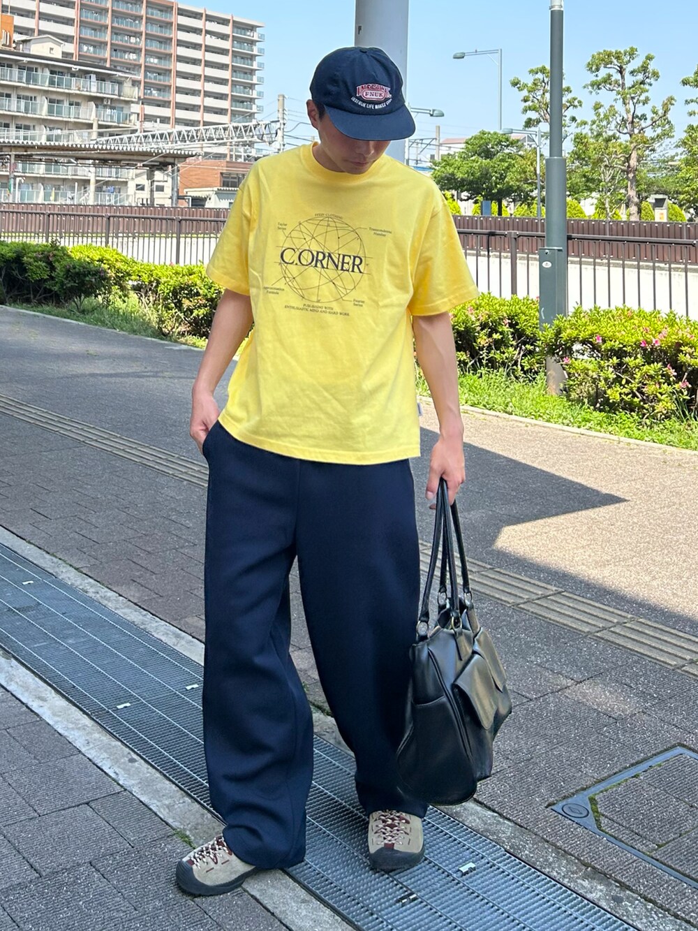 イエロー系のTシャツ/カットソー、ブルー系のスウェットパンツ、ベージュ系のスニーカーを着用したメンズの春コーディネートの2枚目の写真