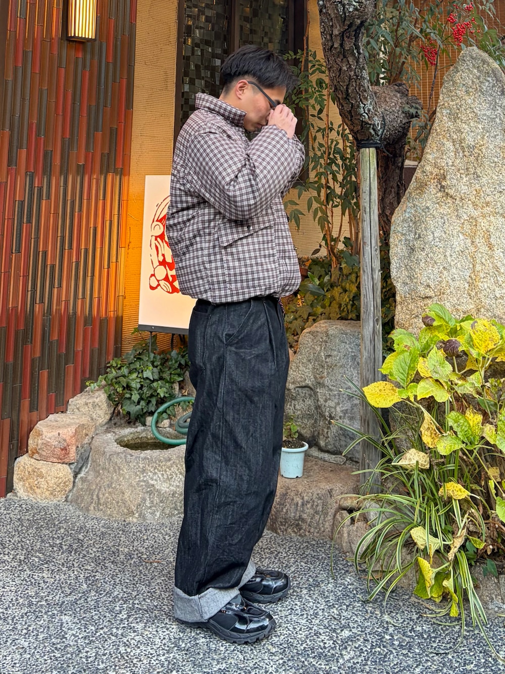 ブラウン系のダウンジャケット/コート、ブラック系のデニムパンツ、ブラック系のスニーカーを着用したメンズの冬コーディネートの3枚目の写真