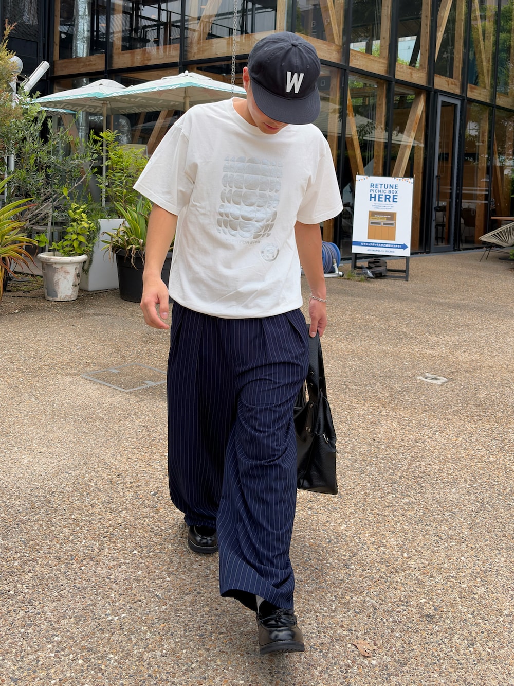 ホワイト系のTシャツ/カットソー、ブルー系のスラックス、ブラック系のショルダーバッグを着用したメンズの夏コーディネートの2枚目の写真