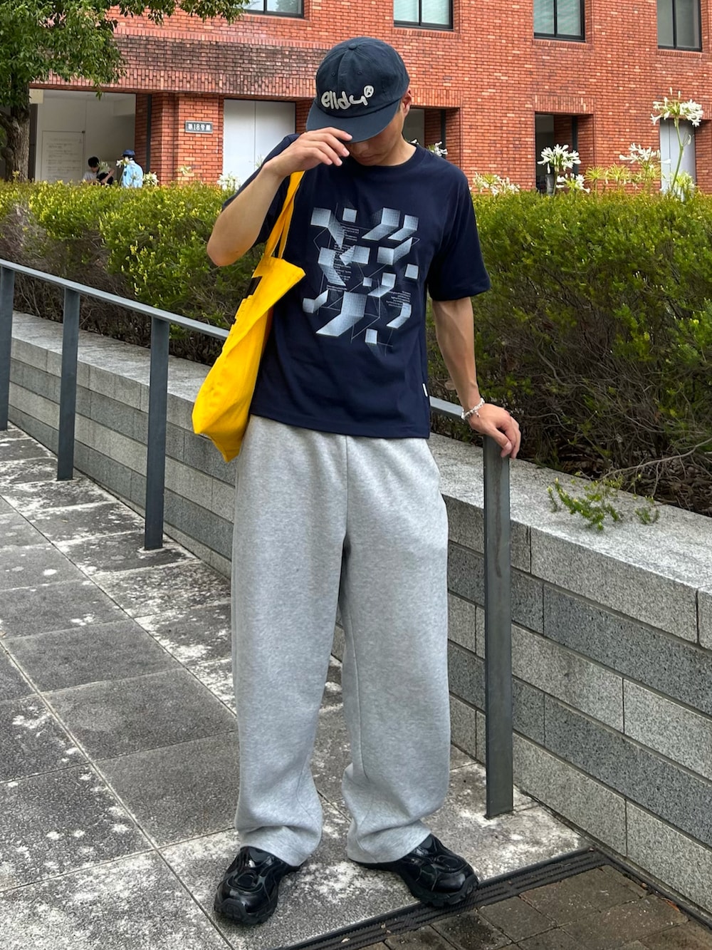 ブルー系のTシャツ/カットソー、グレー系のスウェットパンツ、イエロー系のトートバッグを着用したメンズの夏コーディネートの2枚目の写真