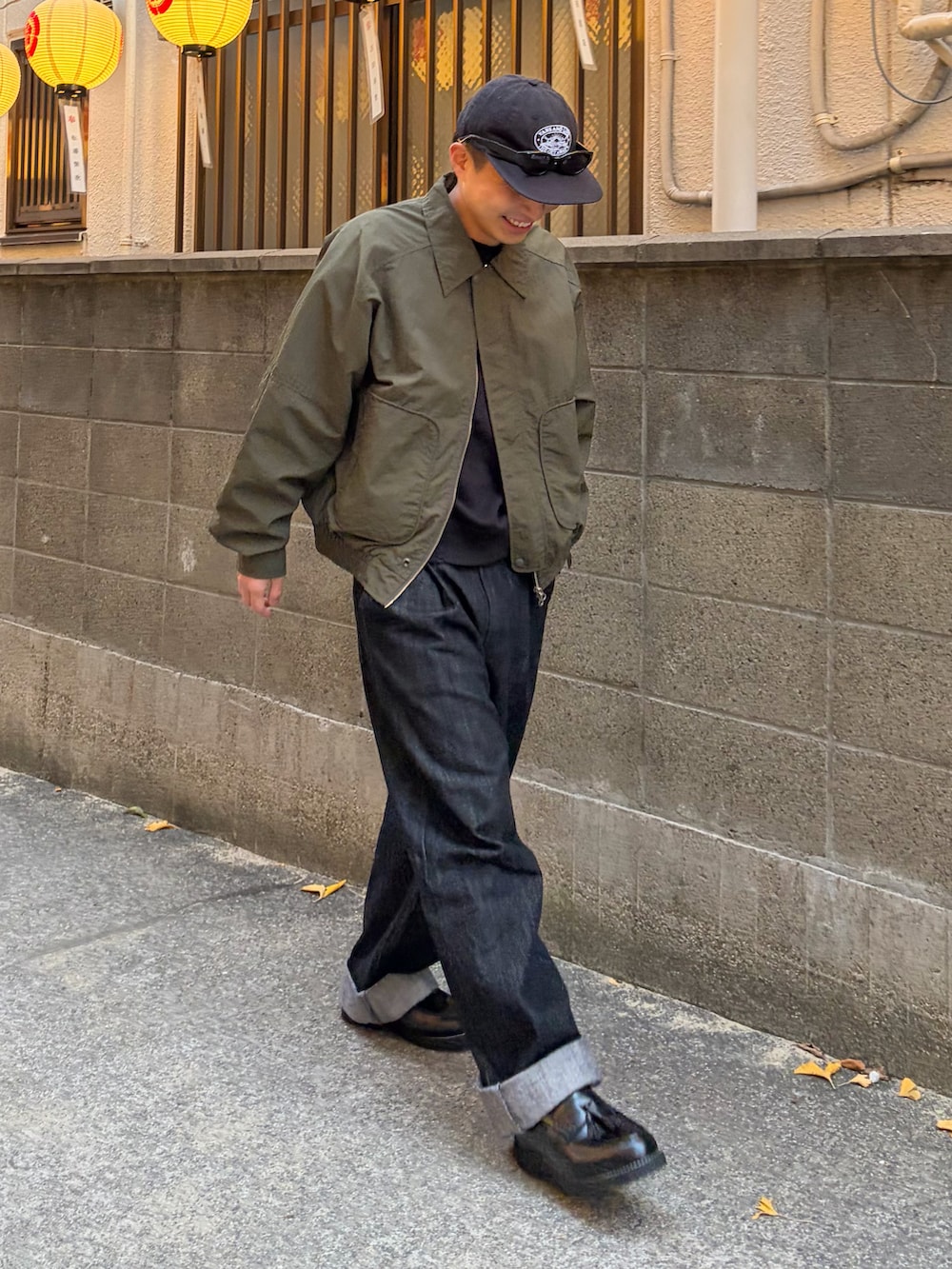 ブラック系のローファー、グリーン系のテーラードジャケット、ブラック系のデニムパンツを着用したメンズの冬コーディネートの3枚目の写真