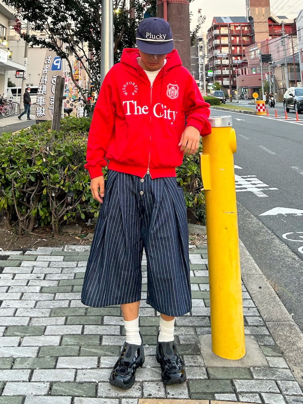 ブルー系のその他パンツ、レッド系のパーカー、ブラック系のスニーカーを着用したメンズの秋コーディネートの2枚目の写真