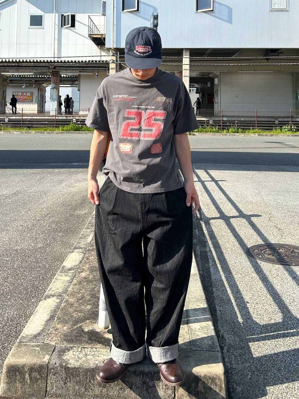 グレー系のTシャツ/カットソー、ブラック系のデニムパンツ、ブラウン系のシューズを着用したメンズの春コーディネートの2枚目の写真