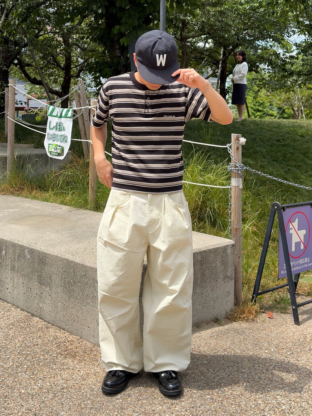 ブラック系のTシャツ/カットソー、ホワイト系のスラックス、ブラック系のローファーを着用したメンズの夏コーディネートの3枚目の写真