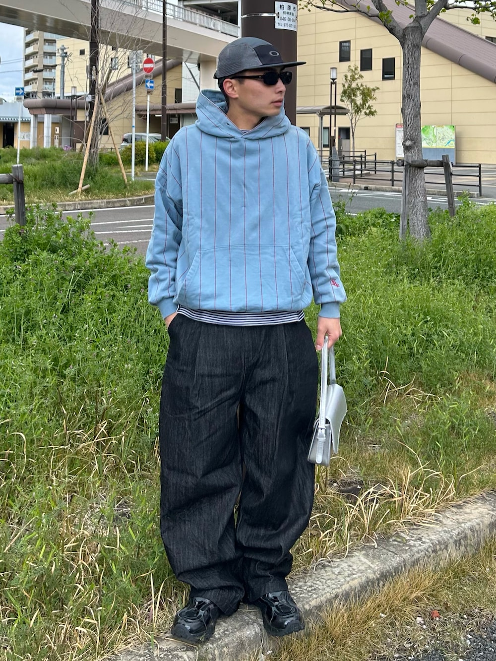 ブラック系のデニムパンツ、ブラック系のスニーカー、ブルー系のパーカーを着用したメンズの春コーディネートの2枚目の写真